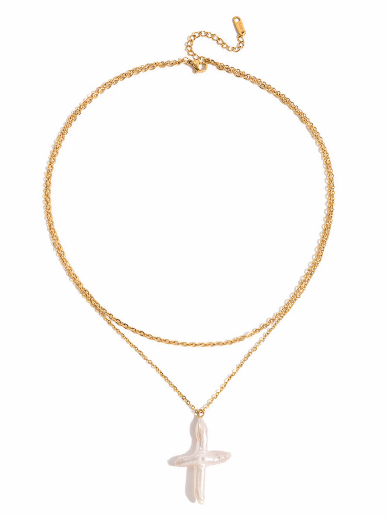 Aegis layered necklace featuring a gold-toned chain and a unique white freshwater baroque pearl cross pendant.