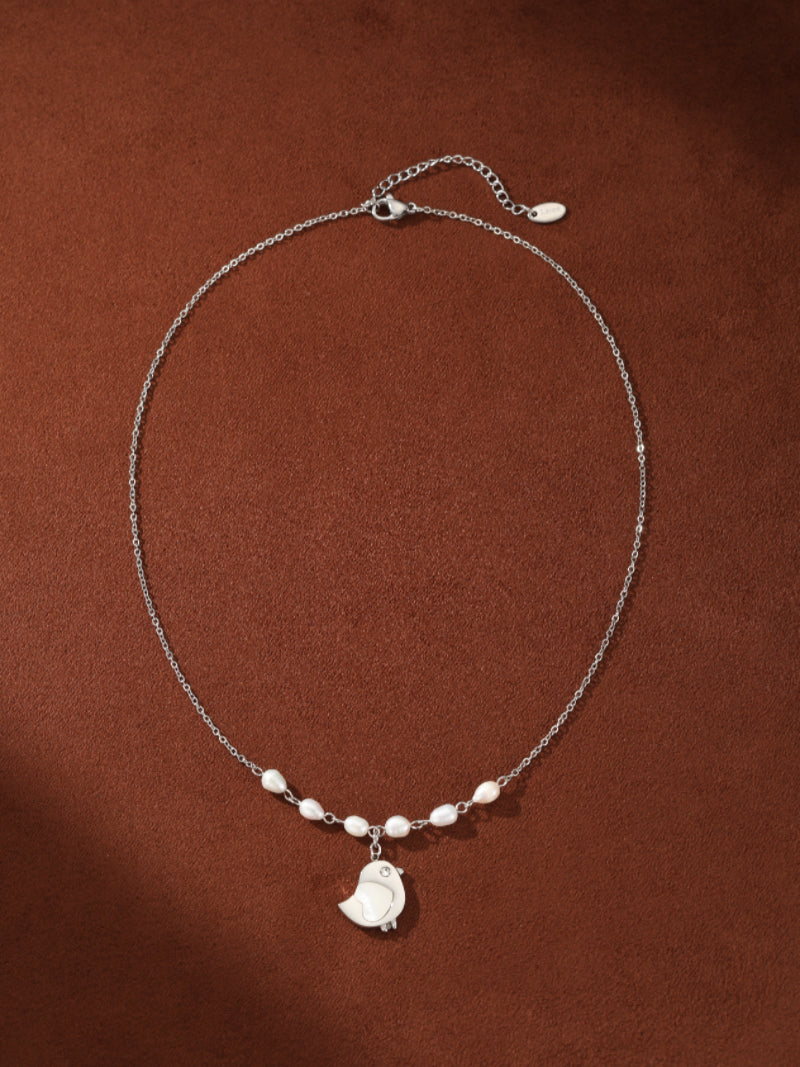 Ascend silver chain necklace featuring a cute bird pendant accented with small white freshwater pearls. @pearl