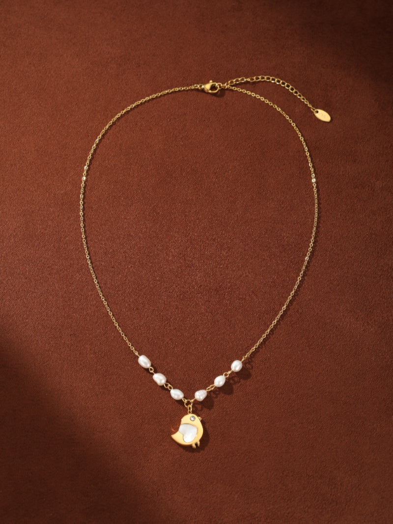 Gold-tone chain necklace with freshwater seed pearls and a bird pendant featuring a white shell inlay, with an adjustable clasp. @pearl