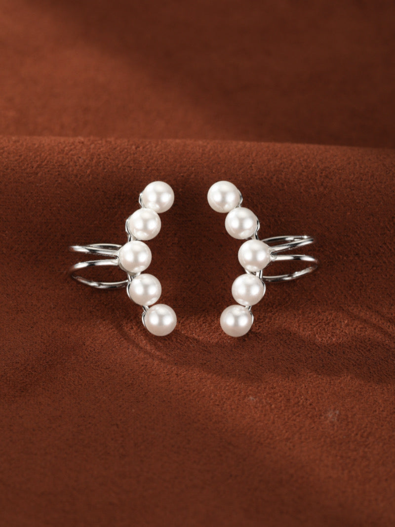 Boucles d'oreilles créoles Ascent en perle d'eau douce présentant un design courbé avec de multiples perles blanches rondes de 5 mm remontant le lobe de l'oreille, serties sur métal ton argent.
