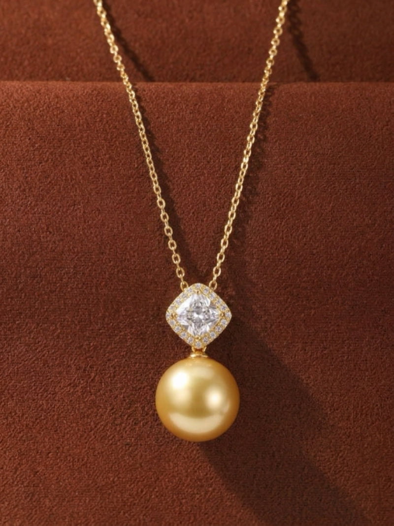 Aurelia South Sea Golden Pearl pendant necklace featuring a large, round 15mm golden pearl suspended from a square-shaped bail adorned with accent stones, set on a delicate gold chain.