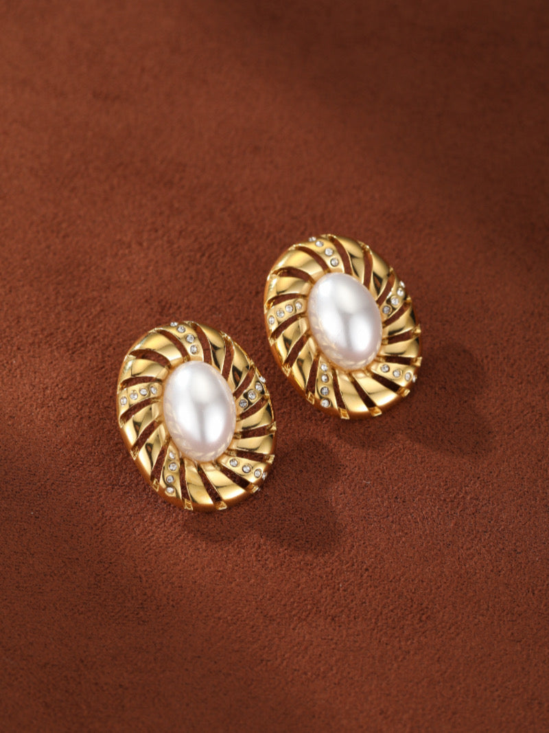 Aurelian stud earrings featuring 12mm freshwater baroque pearls set in gold-toned sculptural spiral settings with sparkling accents.