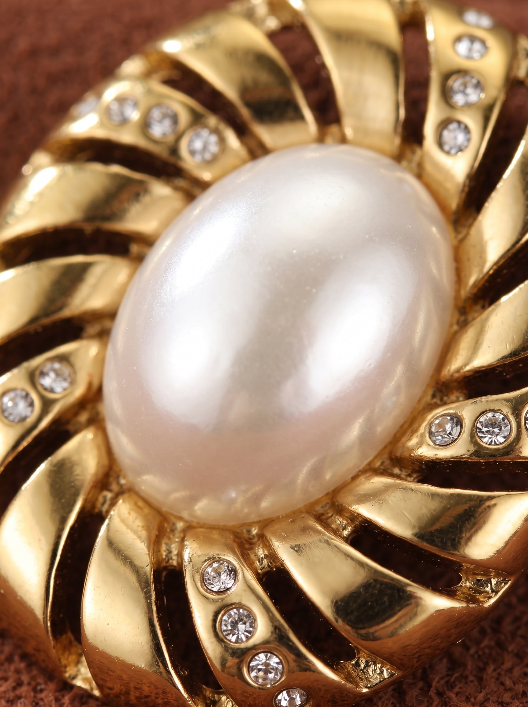 Close-up of a gold-toned Aurelian stud earring featuring a lustrous 12mm freshwater baroque pearl surrounded by a modern, sculptural spiral design with sparkling accent stones. @pearl
