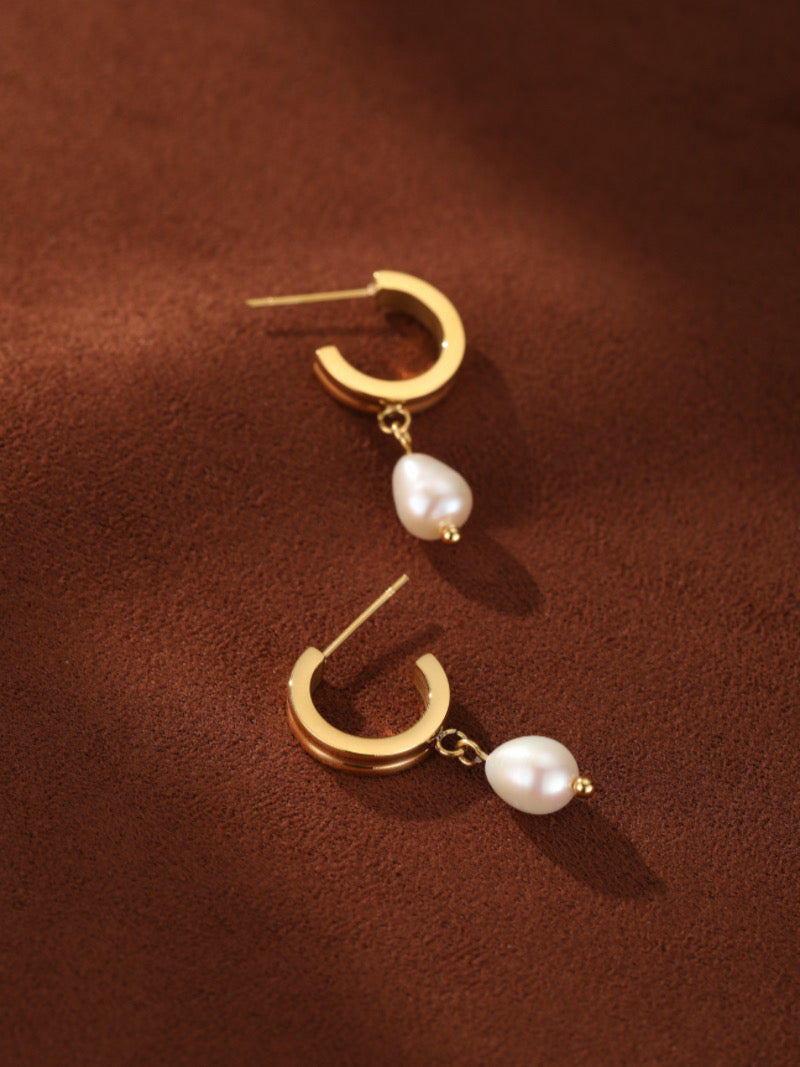 Gold-toned hoop earrings with a single white freshwater pearl drop hanging from each