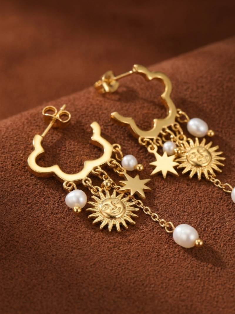 Gold-toned dangle earrings featuring a clover-shaped top with dangling charms of freshwater pearls, stars, and sun faces.