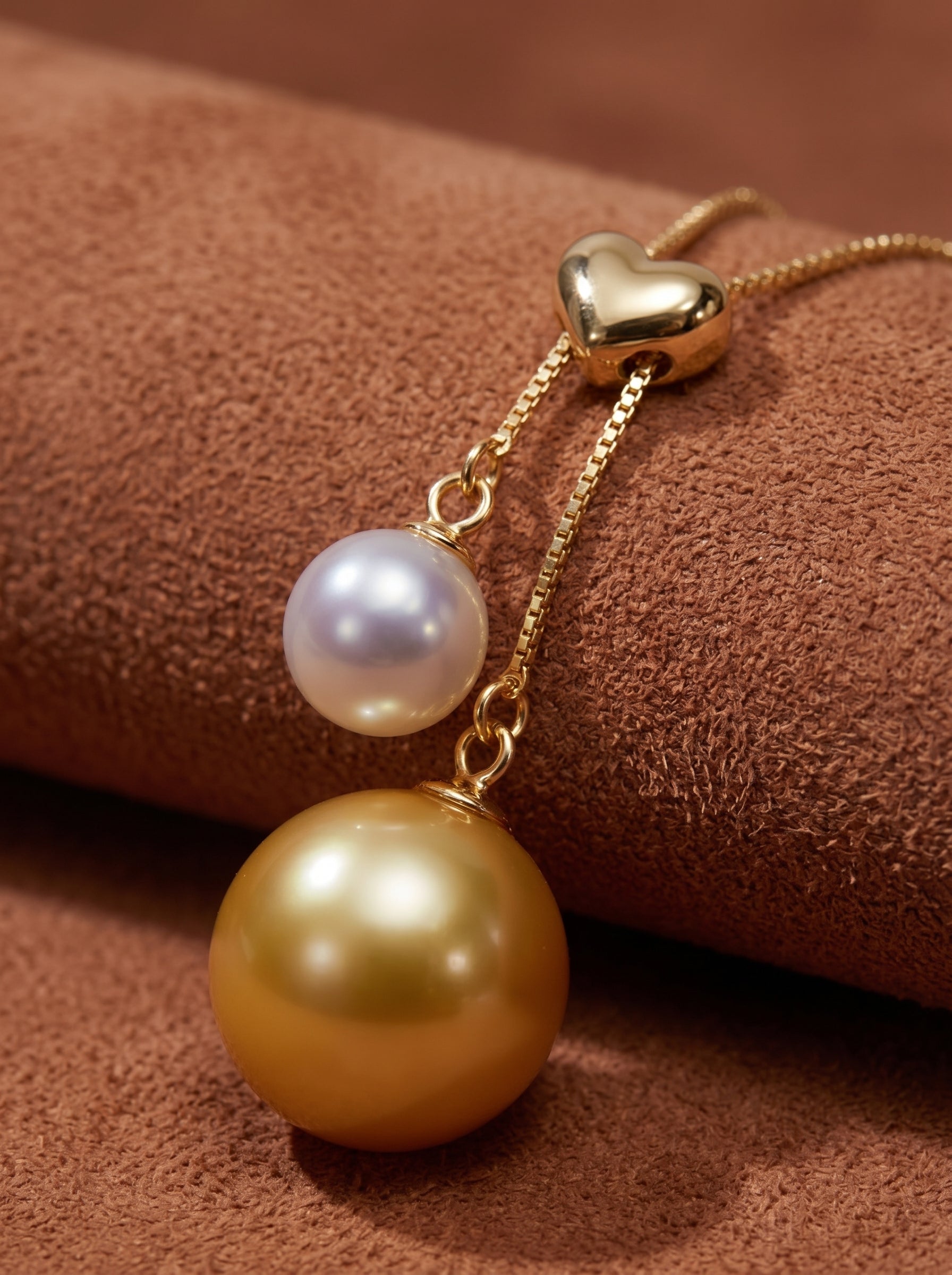 Duet necklace featuring a heart-shaped gold clasp, a lavender Akoya pearl, and a golden South Sea pearl drop on a delicate gold chain. @pearl