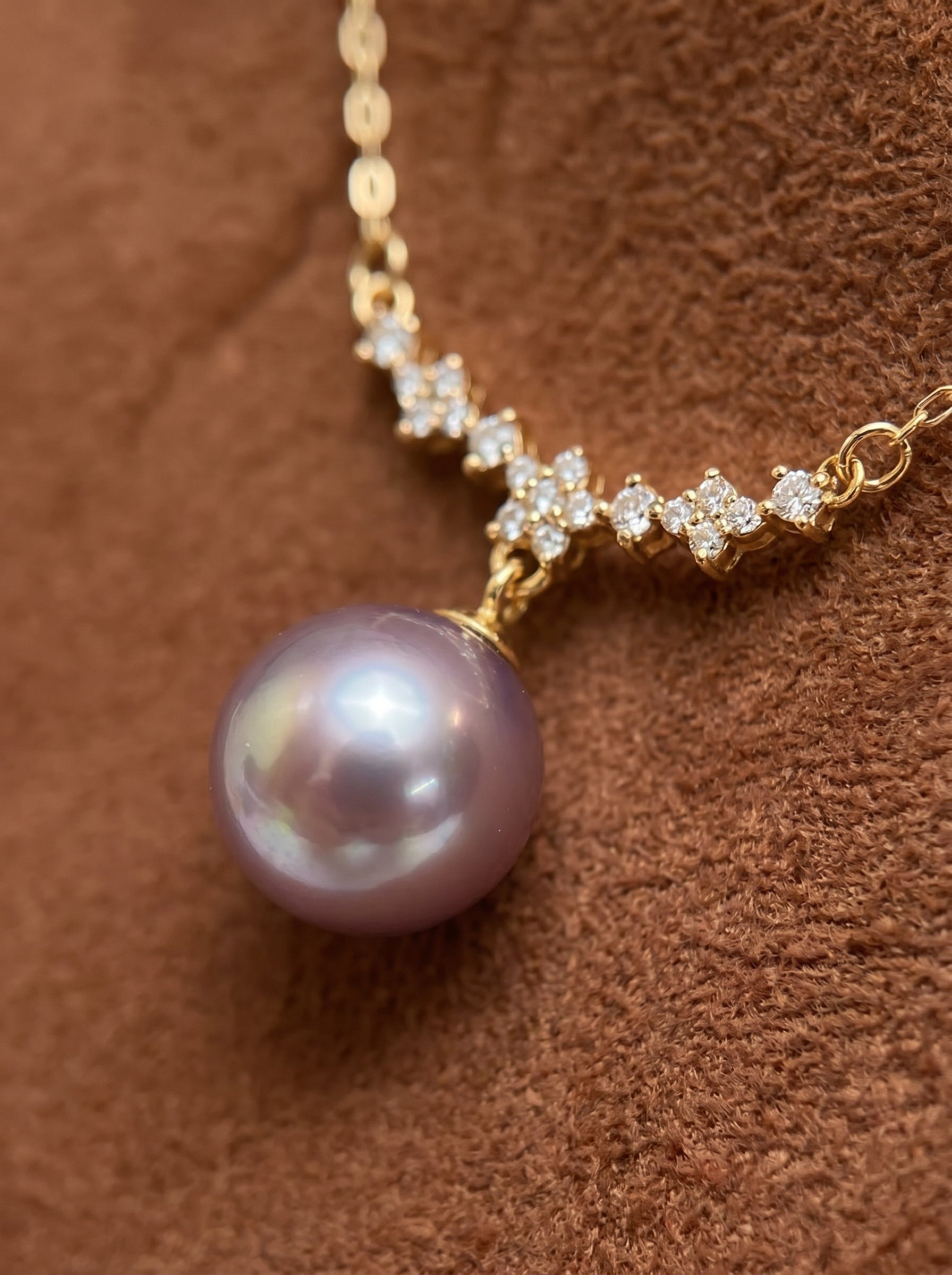 Eclat Freshwater Pearl Star Cluster Drop Necklace featuring a large, lustrous purple freshwater pearl suspended from a delicate gold chain adorned with sparkling star-shaped clusters of cubic zirconia. @pearl