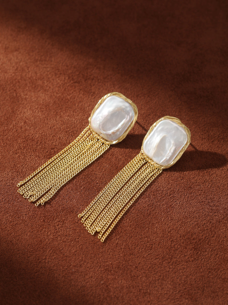 Epoch Fringe gold-toned dangle earrings featuring a unique baroque freshwater pearl stud with a cascading fringe of delicate gold chains below. @pearl