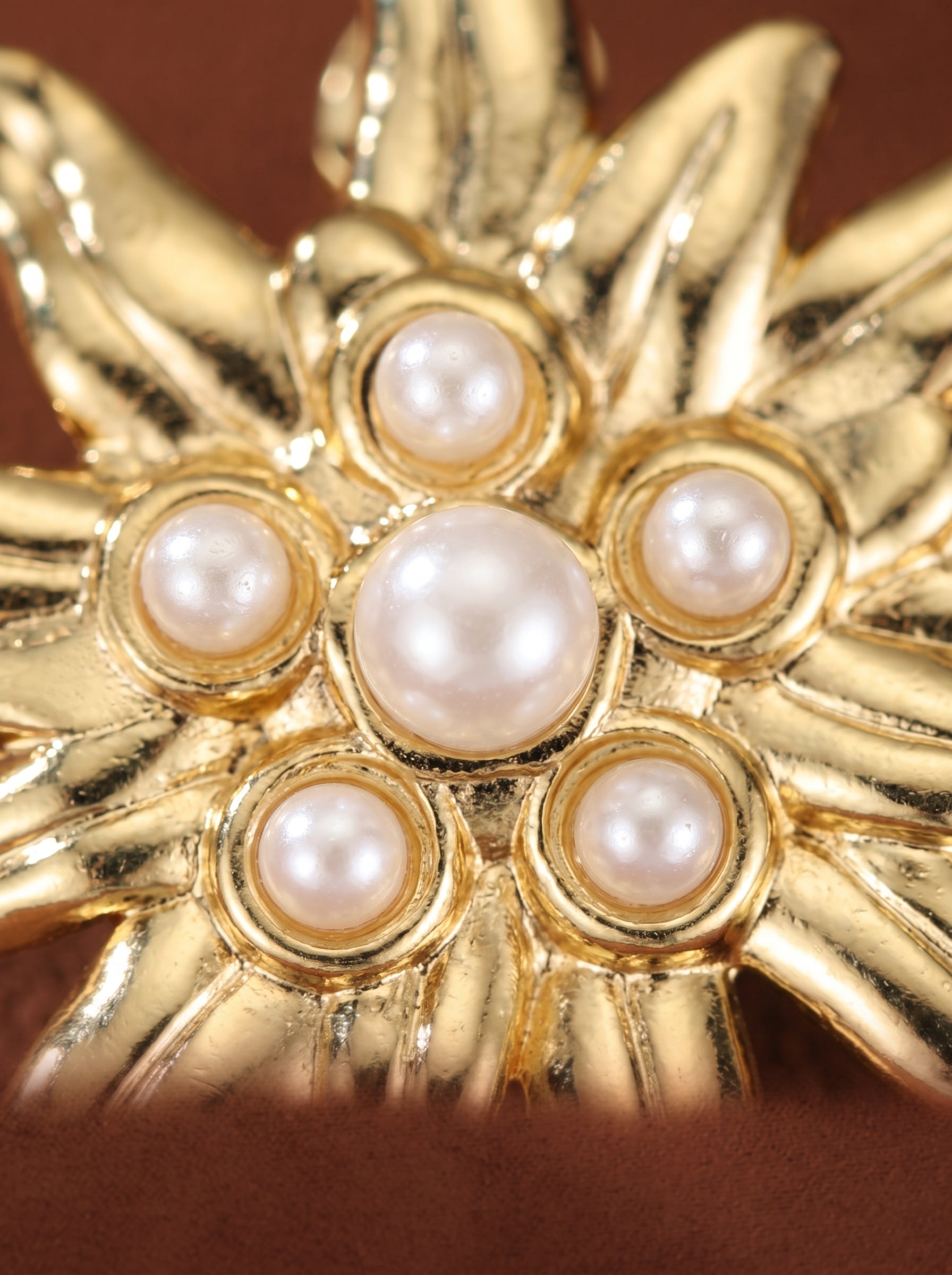 Close-up of Flare imitation pearl flower stud earrings featuring a central 6mm button pearl surrounded by smaller 3mm pearls in a gold-toned frame. @pearl