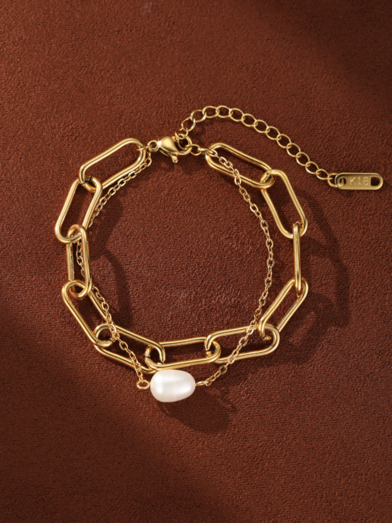 Gold-toned chunky chain bracelet with a delicate secondary chain and a single white baroque freshwater pearl.