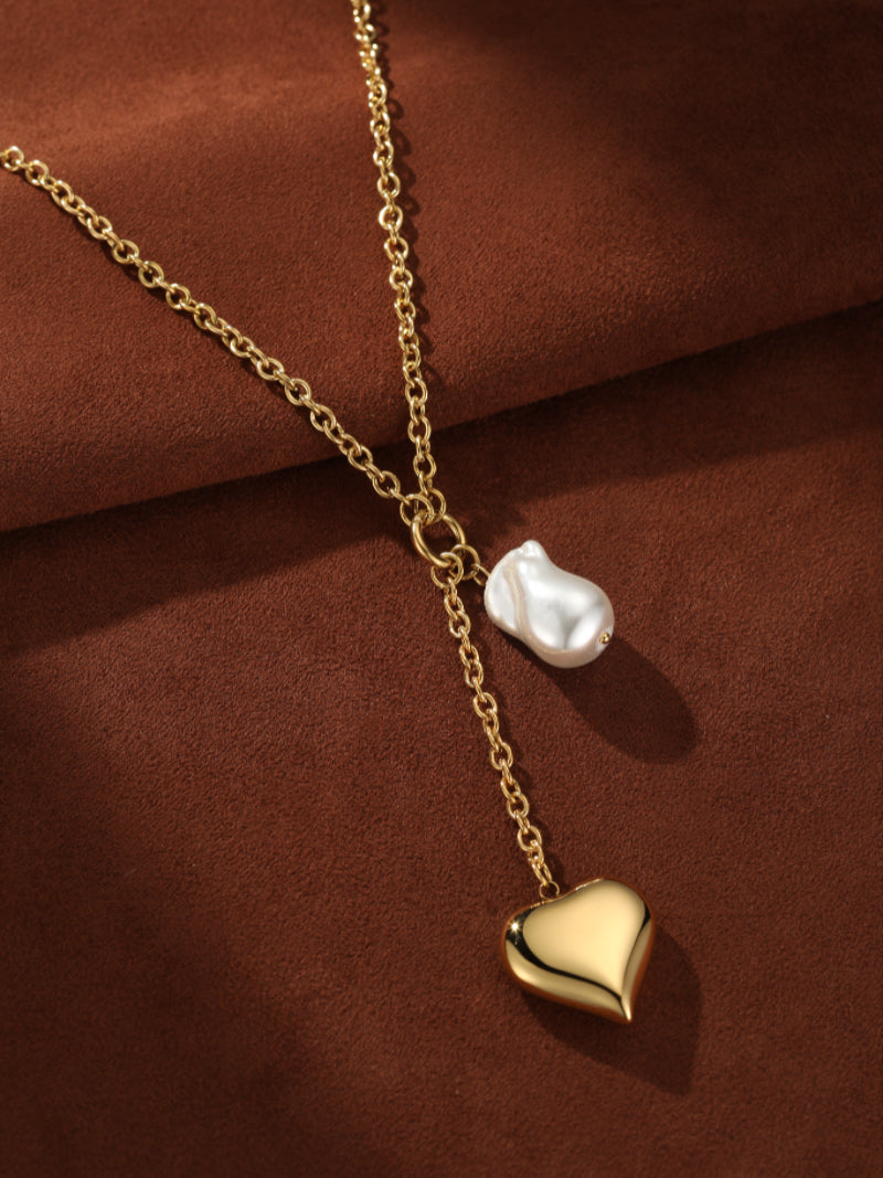 Gilded Muse gold-tone layered chain necklace with a polished heart pendant and a unique baroque freshwater pearl. @pearl