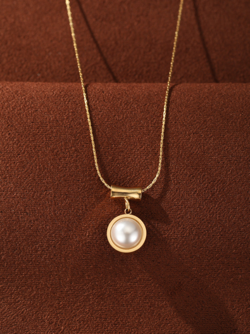 Glimpse - Gold-toned pendant necklace featuring a single 10mm round white freshwater pearl suspended from a horizontal bar on a delicate chain.