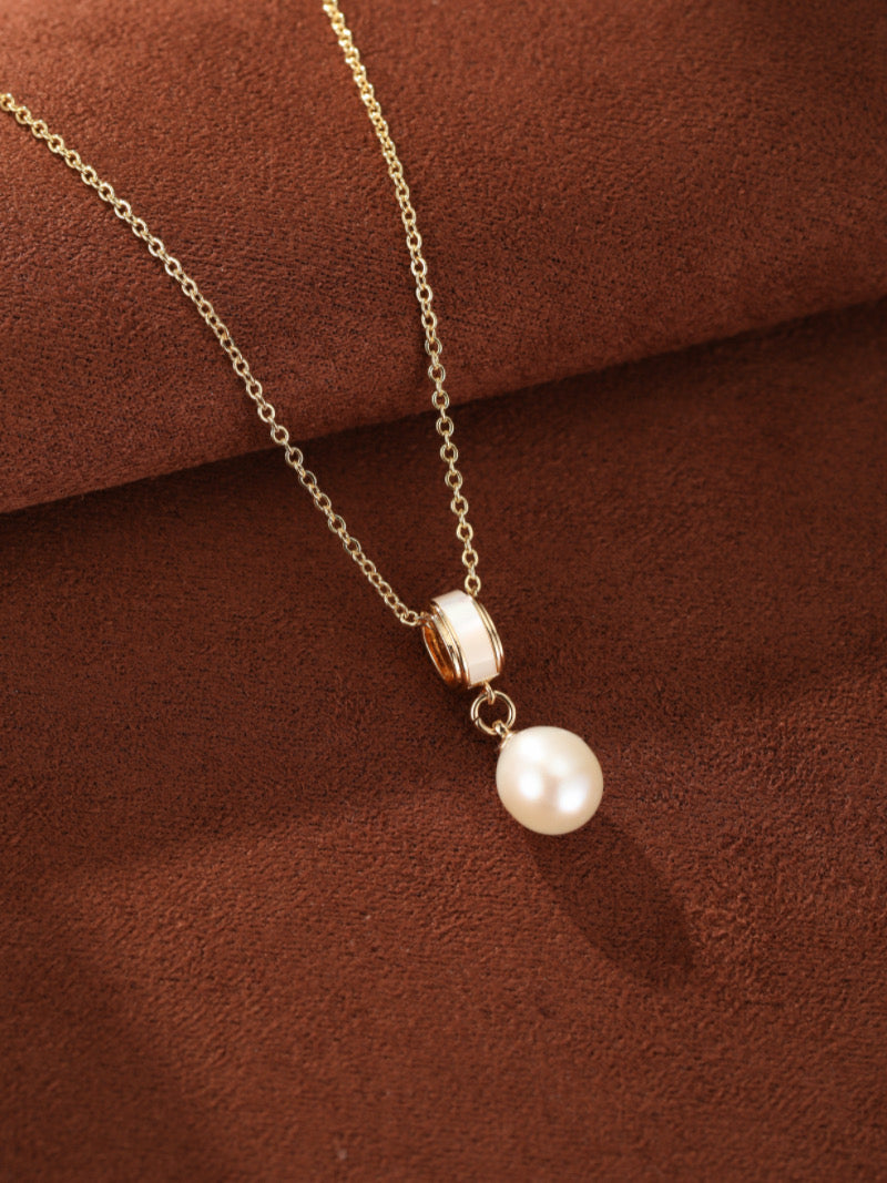 Delicate gold chain necklace featuring a single, luminous white 8mm freshwater pearl drop pendant suspended below a modern cylindrical accent.