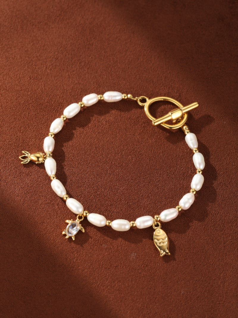 Lagoon Freshwater Pearl Oceanic Charms Beaded Bracelet with turtle, fish, and shell charms and a toggle clasp.