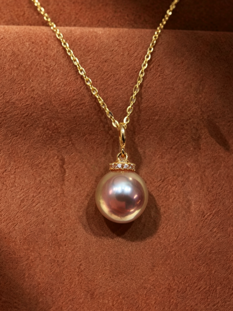 A delicate gold chain necklace featuring a single round purple freshwater pearl drop, accented with tiny crystals at the bail. @perle