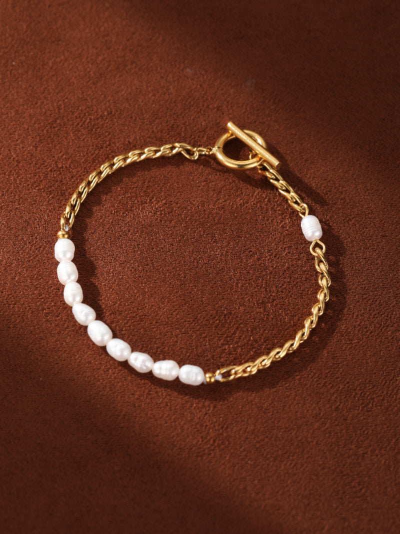 Gold-toned chain bracelet featuring a section of irregular freshwater pearls and a toggle clasp.