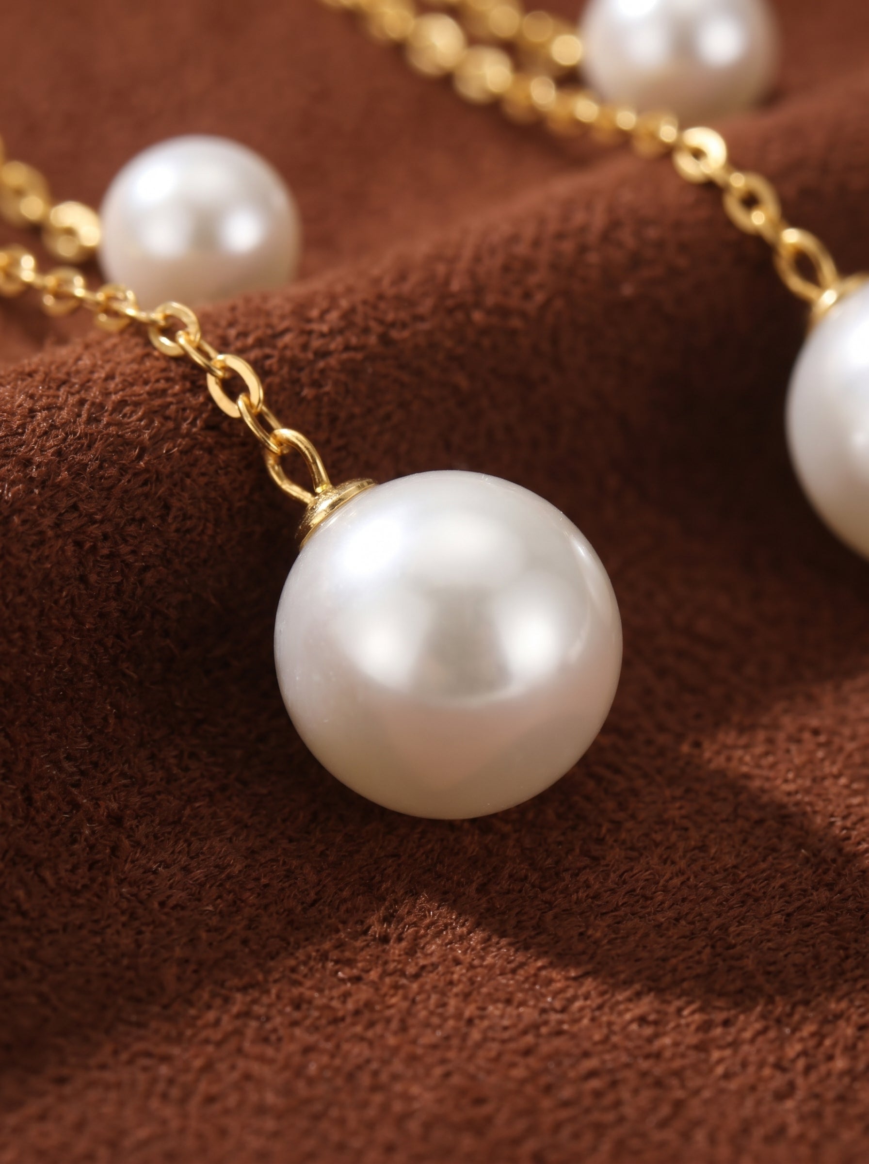 Close-up of luminous drop freshwater pearl chain drop earrings with gold-tone chain and white pearls@pearl