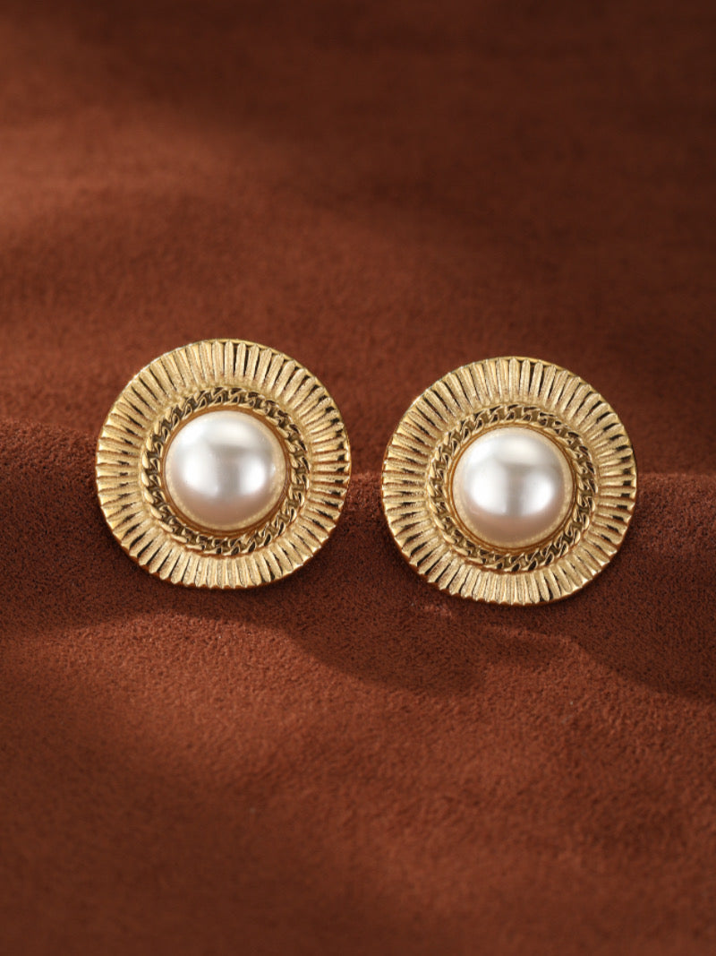 Round gold-toned stud earrings featuring a central 12mm freshwater white button pearl surrounded by a textured sunburst-inspired frame and a delicate chain-link detail.