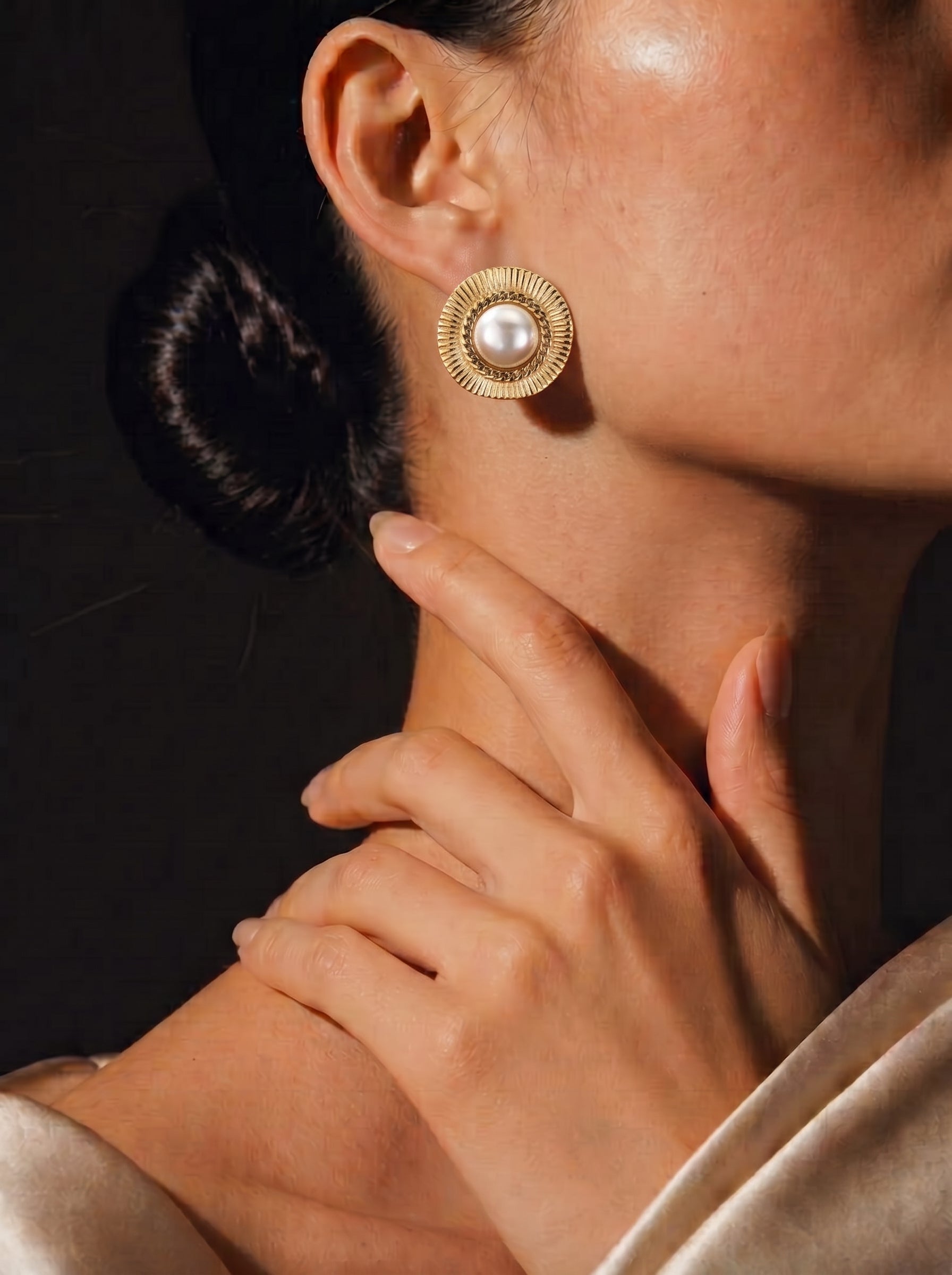 Close-up of a woman wearing Meridian Shine gold-toned sunburst stud earrings with a 12mm freshwater pearl center. @model