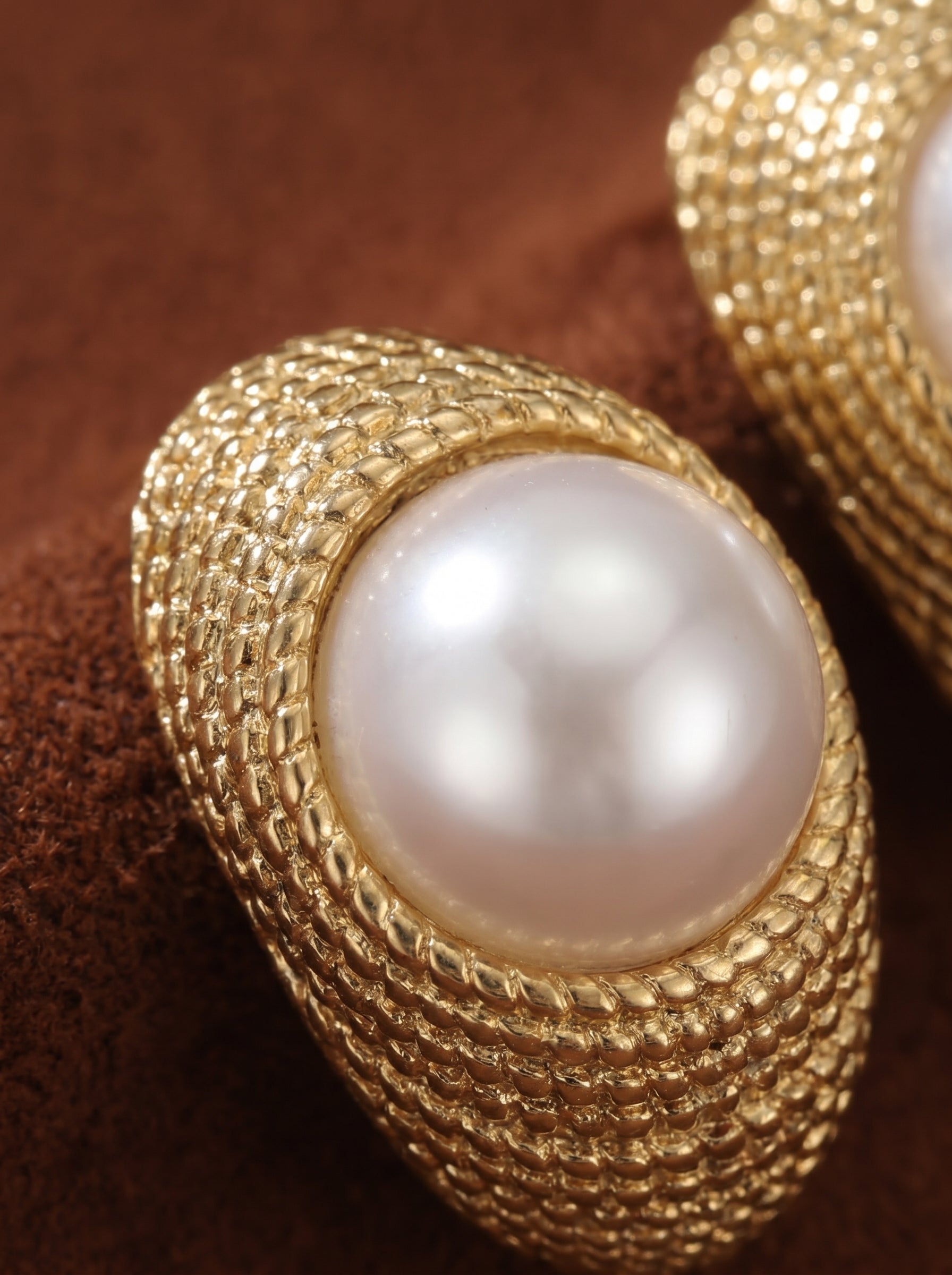Orbit textured gold-tone stud earrings featuring a lustrous white freshwater pearl set in a hammered gold frame. @pearl