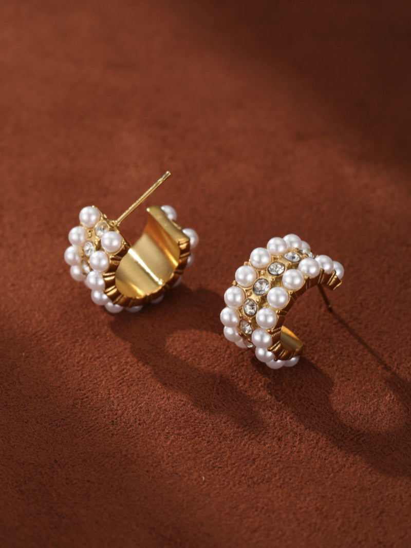 Gold-toned hoop earrings adorned with multiple rows of lustrous white freshwater pearls and sparkling crystals.