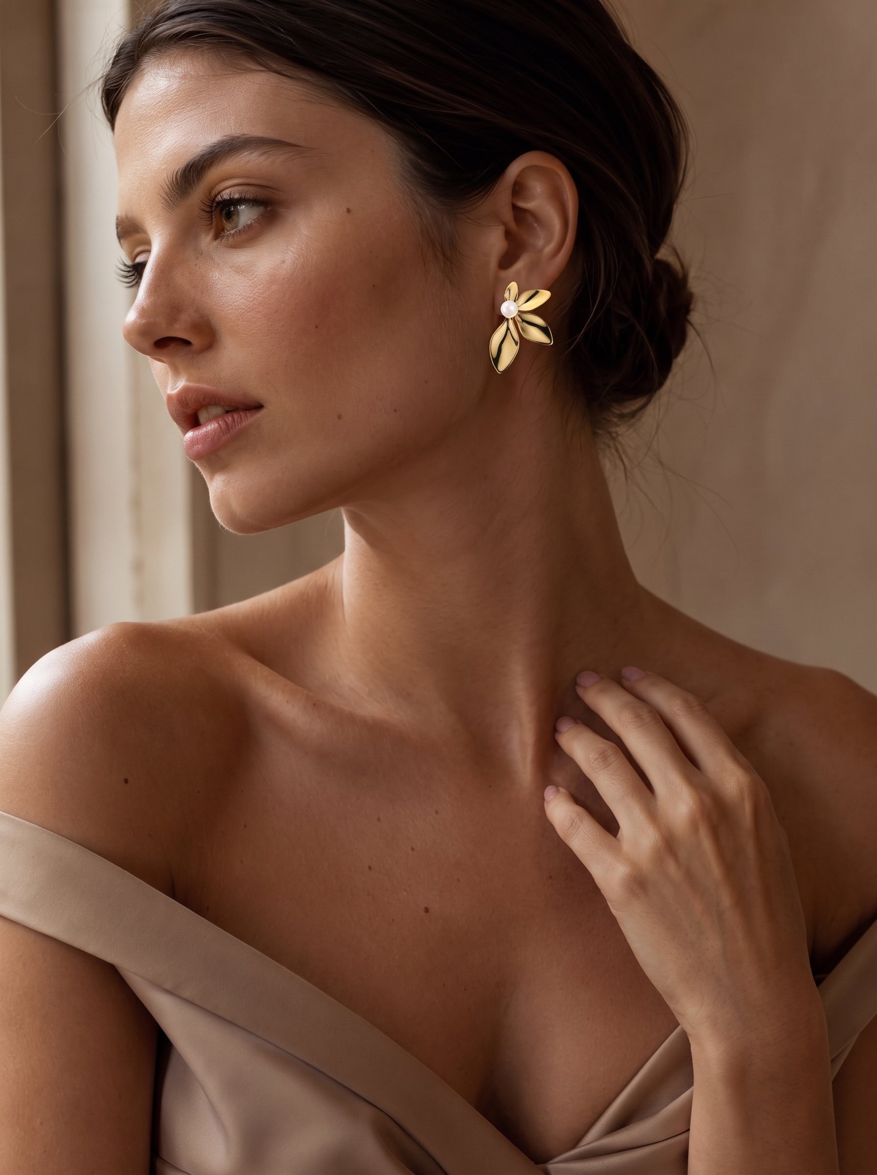 Une femme portant une robe dénudée beige et les boucles d'oreilles puces florales Sprout en perle d'eau douce avec un centre en perle. @lifestyle