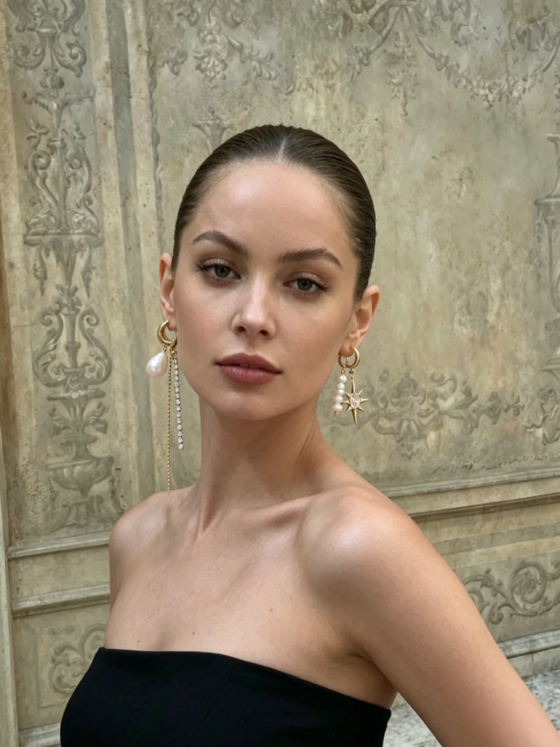 Close-up of a woman wearing the Stardust Freshwater Pearl Star Hoop Dangle Earrings, featuring asymmetric design with a pearl and a star motif. @model
