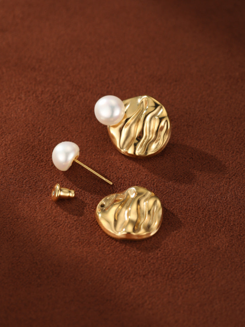 Boucles d'oreilles puces ton or présentant une lustrée perle blanche ronde d'eau douce de 4 mm au sommet d'un disque au motif texturé et ondulé complexe.