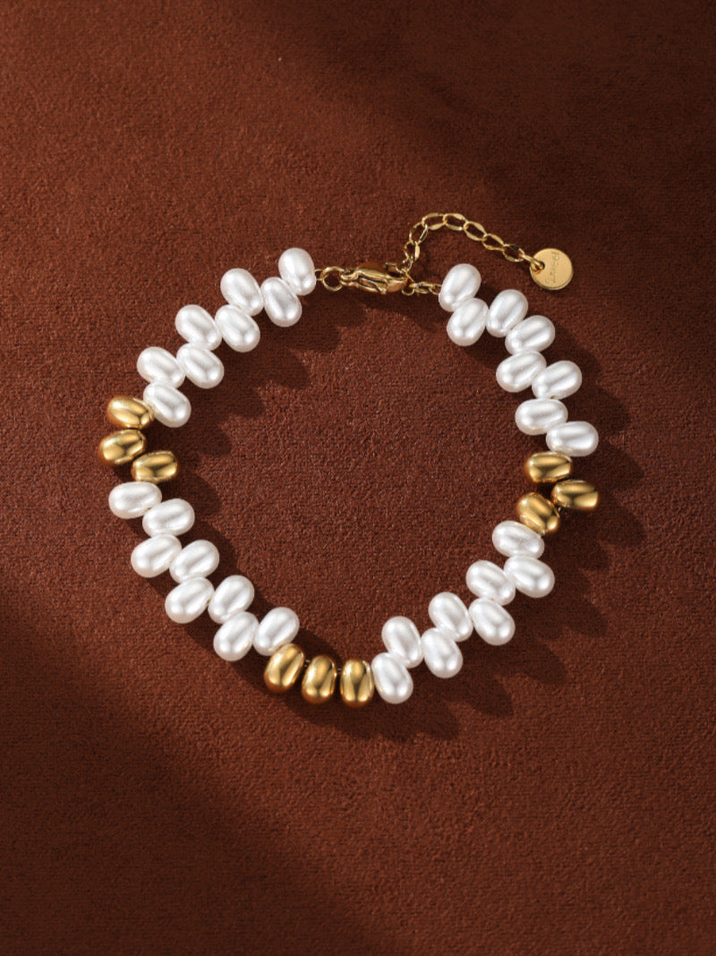 A Sylvan Freshwater Pearl Beaded Bracelet with gold-toned beads on a brown background.