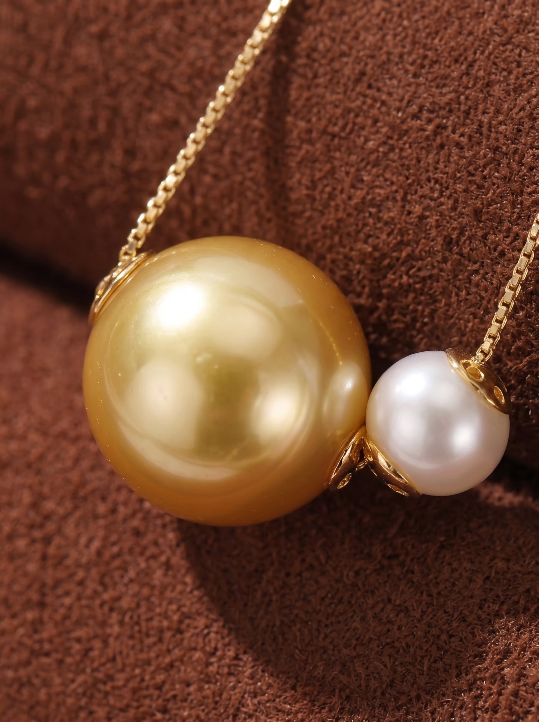 Synergy pendant necklace featuring a large golden South Sea pearl and a smaller white Akoya pearl, suspended on a delicate gold chain. @pearl