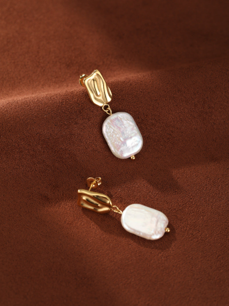 Boucles d'oreilles goutte Undulate présentant des puces dorées texturées et des perles baroques blanches irrégulières d'eau douce.