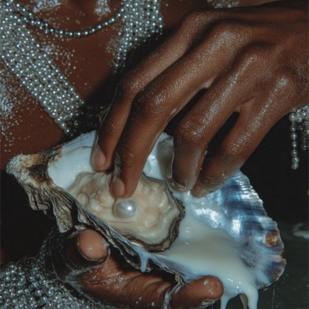 Hands wearing woven pearl armor holding an open oyster with a large, luminous white pearl