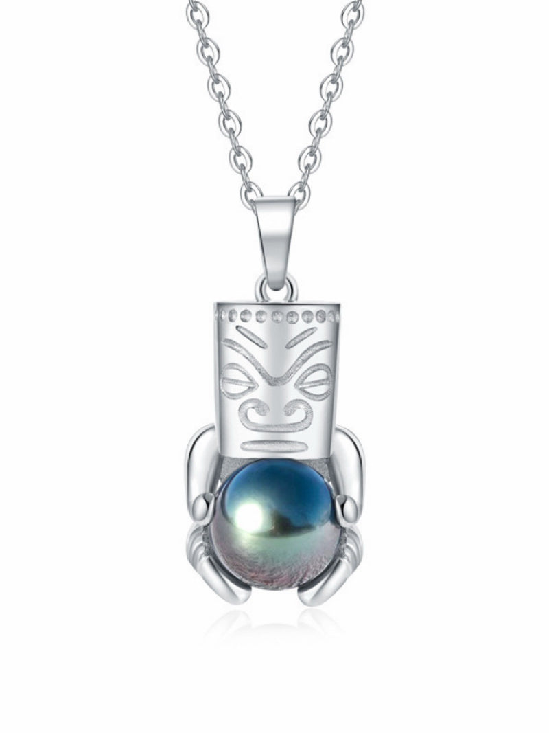 Silver tiki pendant necklace holding a luminous 10mm round Tahitian pearl with blue and green iridescence. @pearl