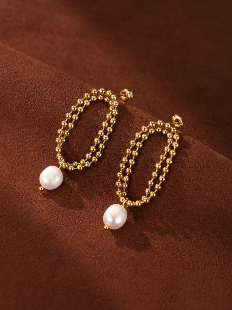 A pair of gold-tone Aperture Freshwater Pearl Drop Earrings featuring a double-strand beaded oval design with a lustrous 8mm white freshwater pearl dangling from each.