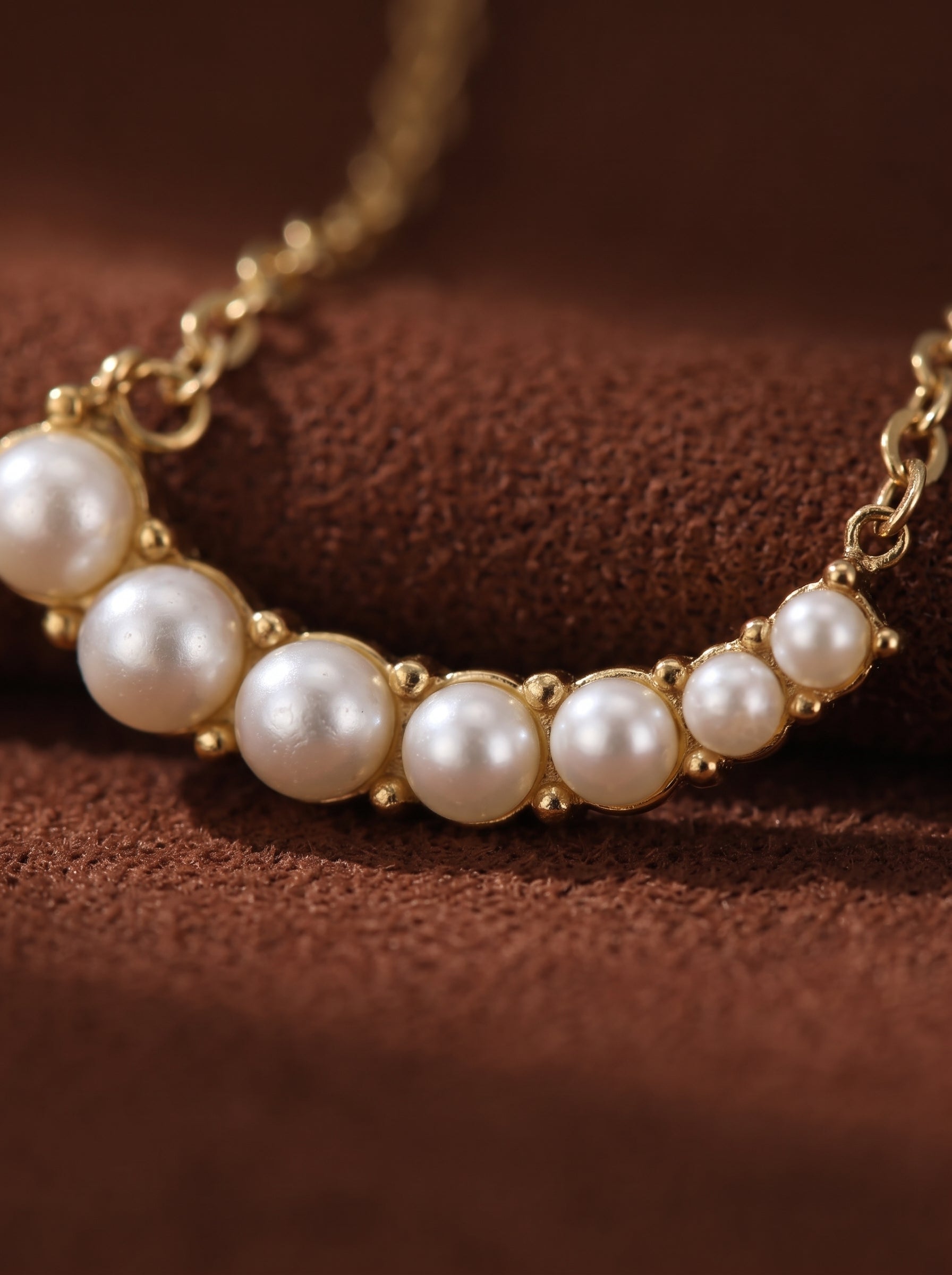 Arcadia - Freshwater Pearl Curved Bar Necklace with a gold chain and nine white freshwater pearls in varying sizes set on a curved bar. @pearl