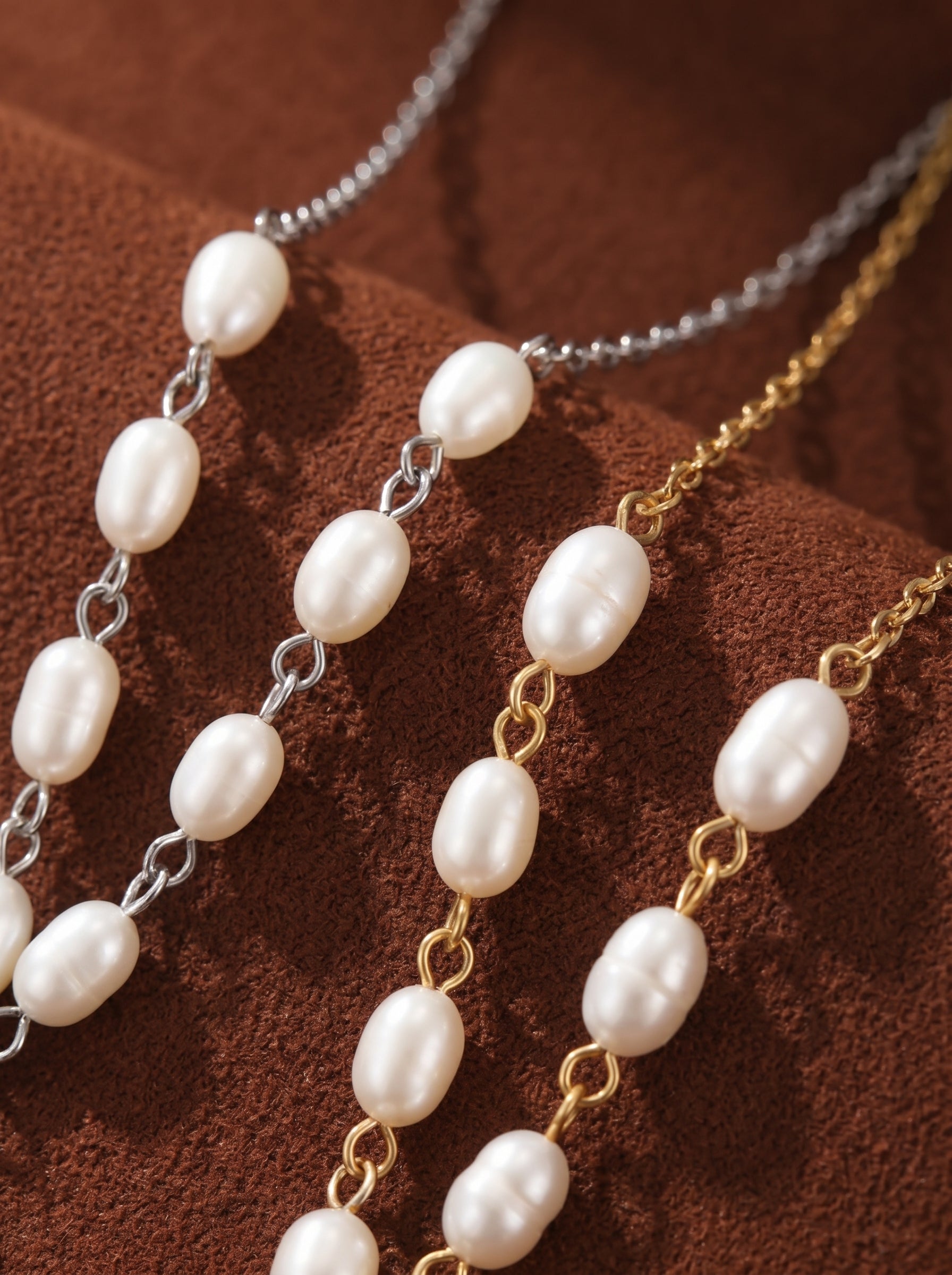 Close-up of two Ascend freshwater pearl bird chain pendant necklaces, one in silver tone and one in gold tone, showcasing their delicate chains and lustrous seed pearls.@pearl