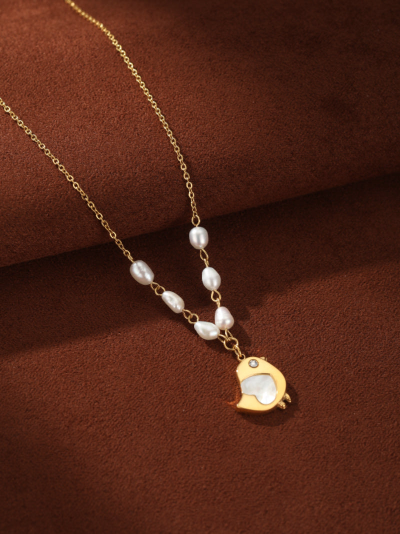 Gold-tone chain necklace with freshwater seed pearls and a charming bird pendant inlaid with mother-of-pearl and a small diamond accent. @pearl