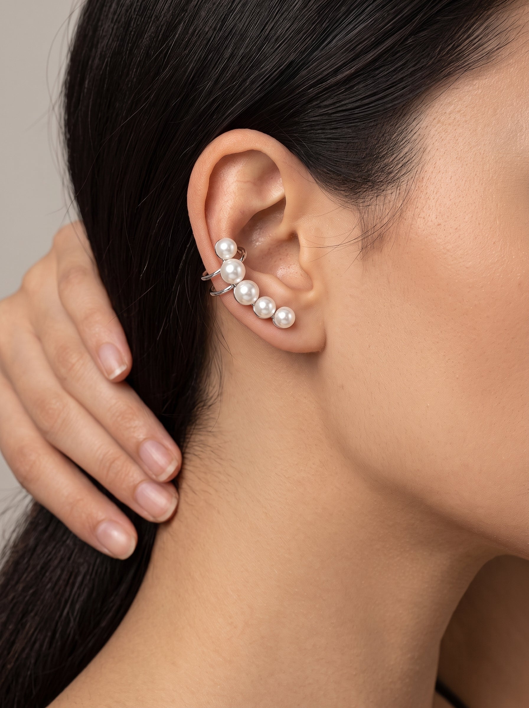 Boucles d'oreilles créoles Ascent en perle d'eau douce révélant de lustrées perles blanches rondes de 5 mm remontant le lobe de l'oreille sur une mannequin. @model