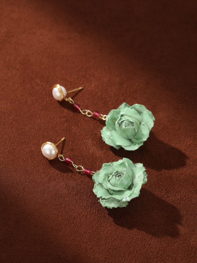 Awaken dangle earrings featuring white freshwater pearl studs connected by a gold-toned chain with pink beads to a mint green flower pendant. @pearl