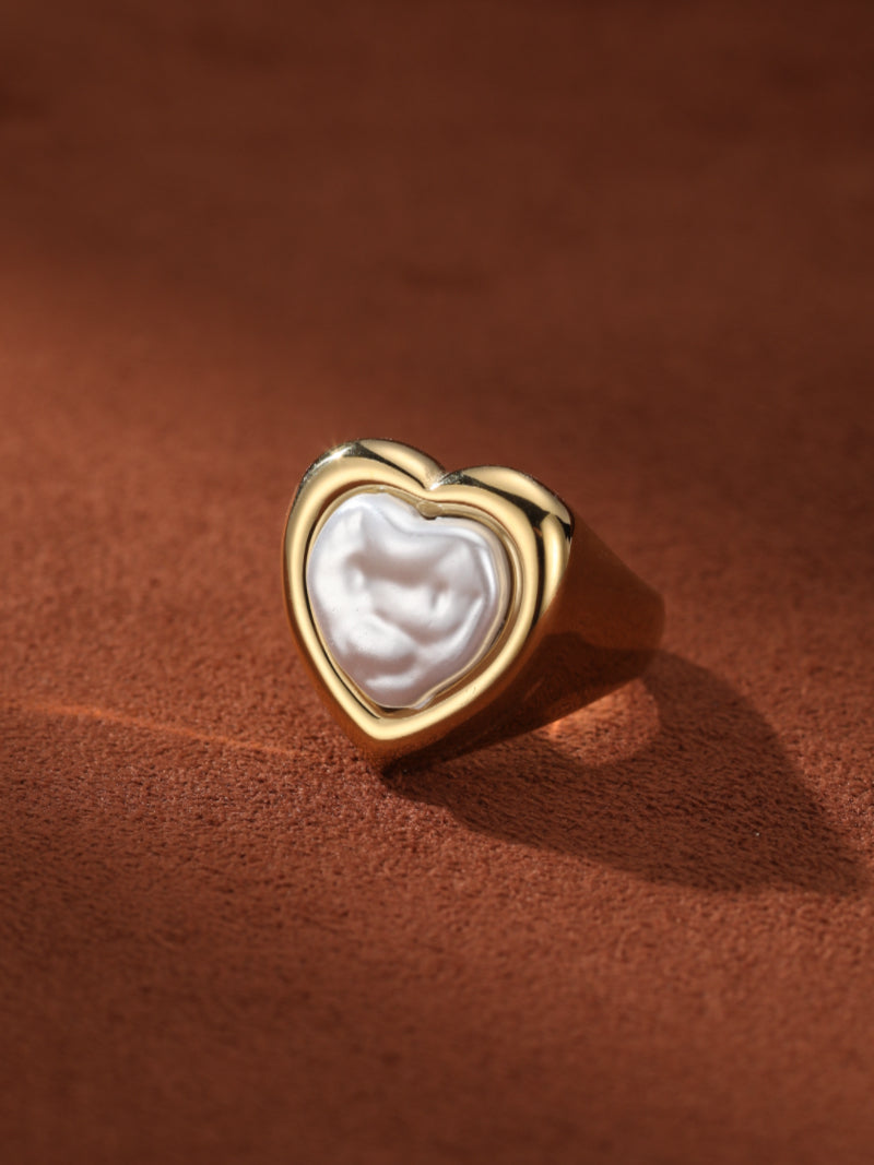 Gold-tone cuff ring with a heart-shaped bezel holding a lustrous Baroque freshwater pearl.