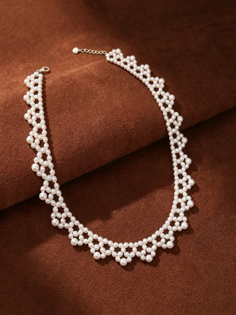 Cipher Freshwater Pearl Woven Choker Necklace featuring a delicate lattice pattern of small white pearls on a brown textured background