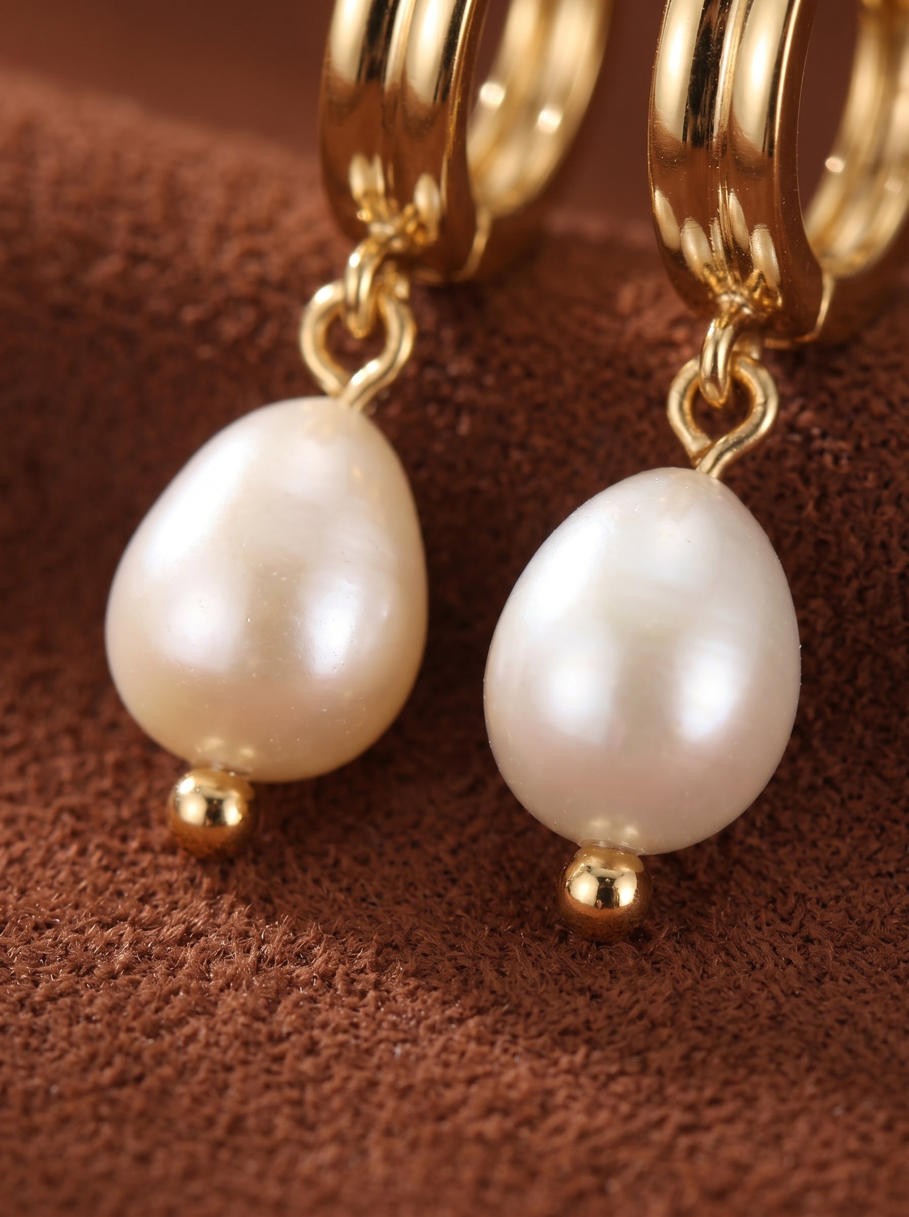 Gold hoops with dangling white freshwater pearl drops, each accented with a small gold bead at the bottom. @pearl