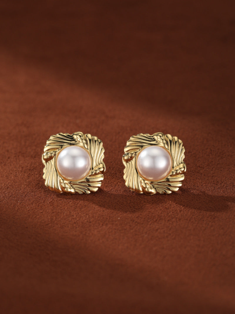 Boucles d'oreilles puces carrées Coffer présentant une lumineuse perle baroque blanche d'eau douce sertie dans un cadre texturé ton or.
