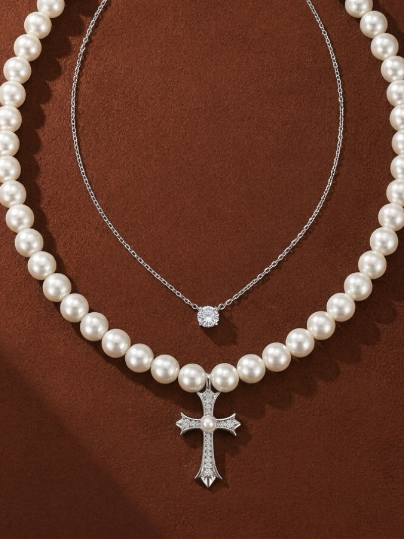 Covenant layered necklace featuring a strand of 6mm white imitation pearls with a diamond-accented cross pendant and a second delicate silver chain with a solitaire stone.
