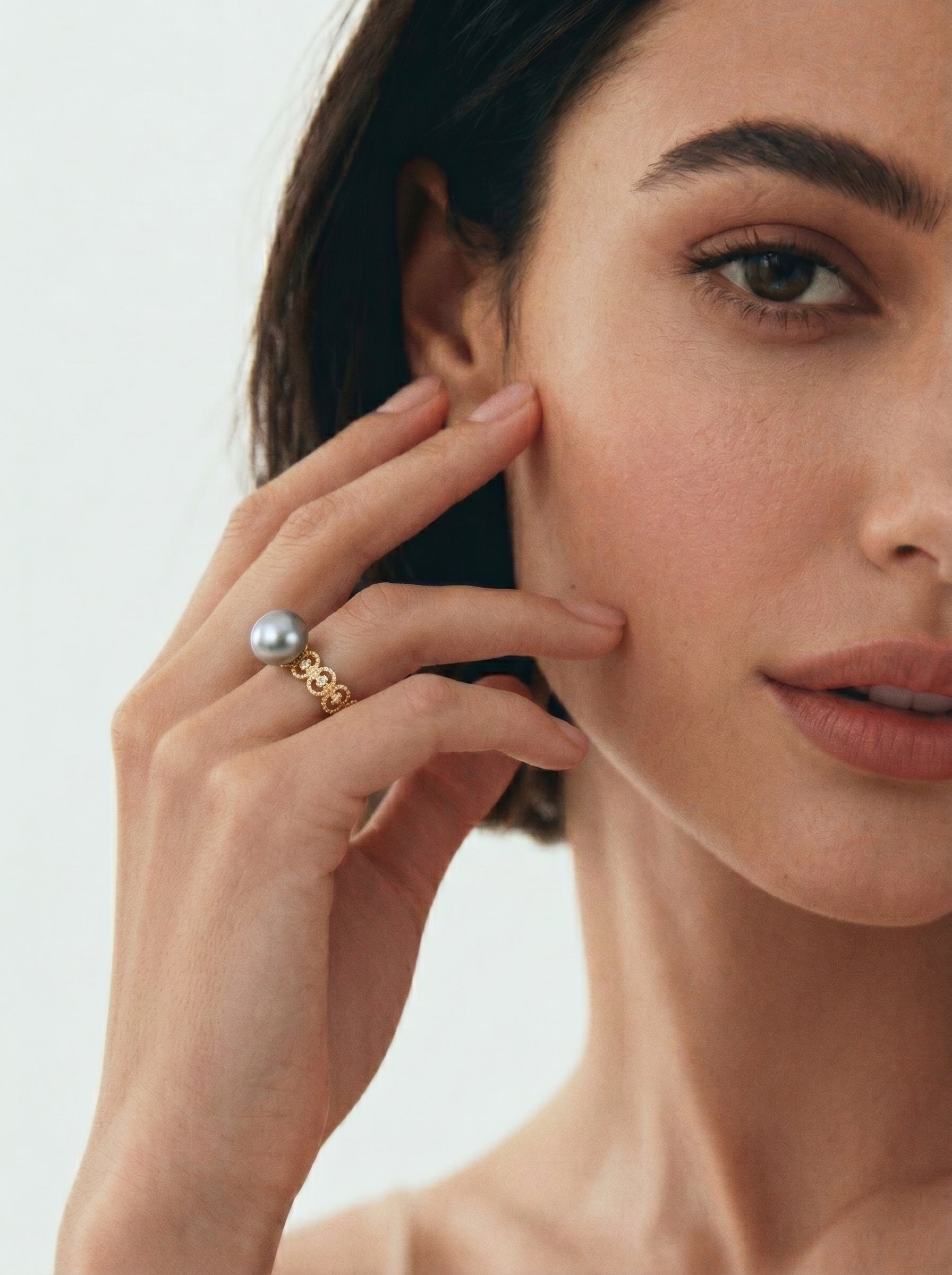 Ecliptic Freshwater Pearl Cuff Ring with a silver pearl on a gold-toned band with circular details, worn by a model. @model