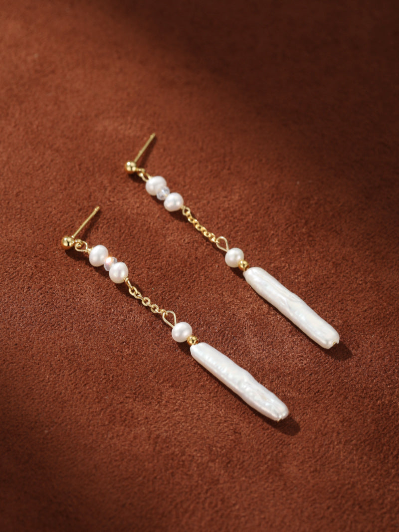 Flow - Flow Freshwater Pearl Long Dangle Earrings featuring delicate 2mm white seed pearls transitioning into striking 25mm white baroque pearls with a gold chain and stud backing.