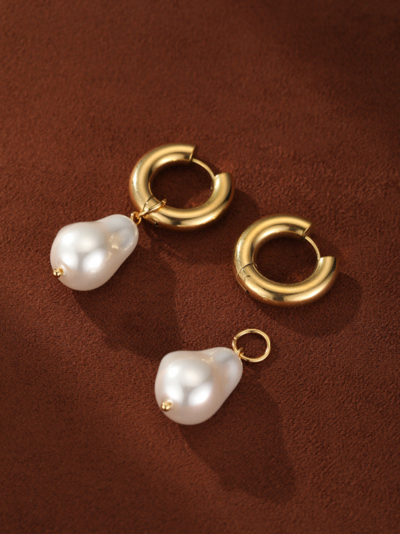 Forma gold-toned chunky hoop earrings with detachable baroque freshwater pearl dangles on a brown background.