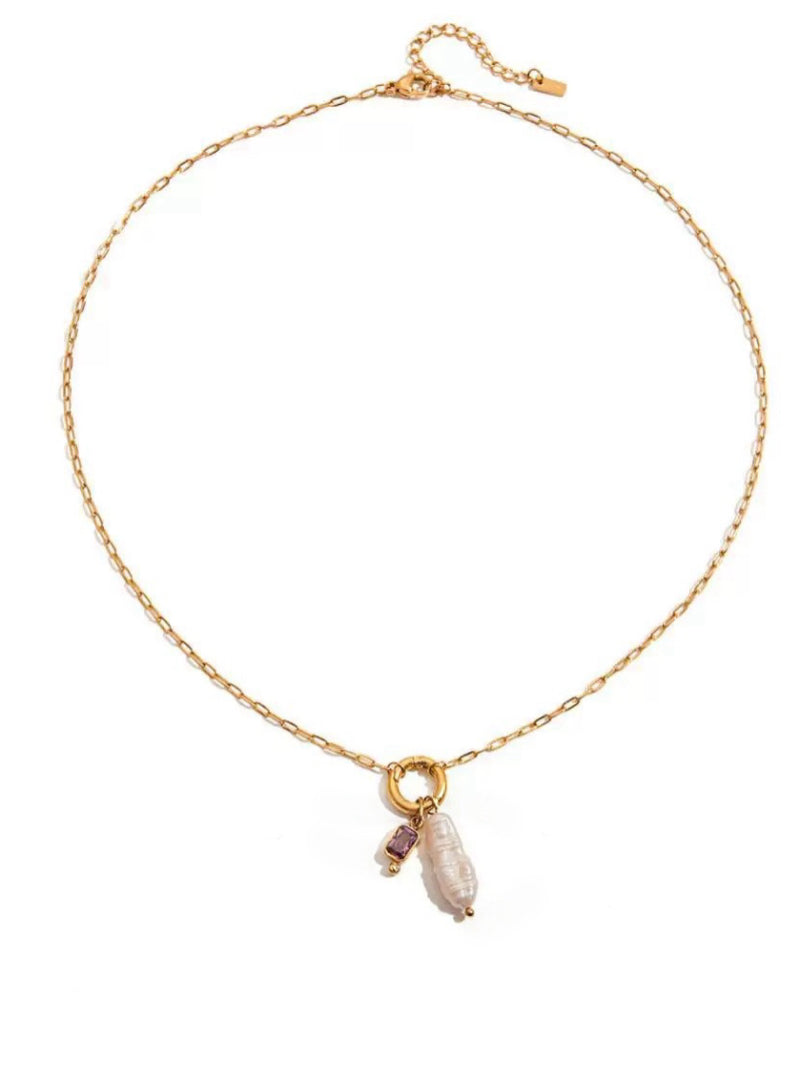 A gold-tone necklace with a delicate chain featuring a single drop pendant. The pendant consists of a small, rectangular purple gemstone and a large, irregular white freshwater pearl. The necklace is displayed on a white background.