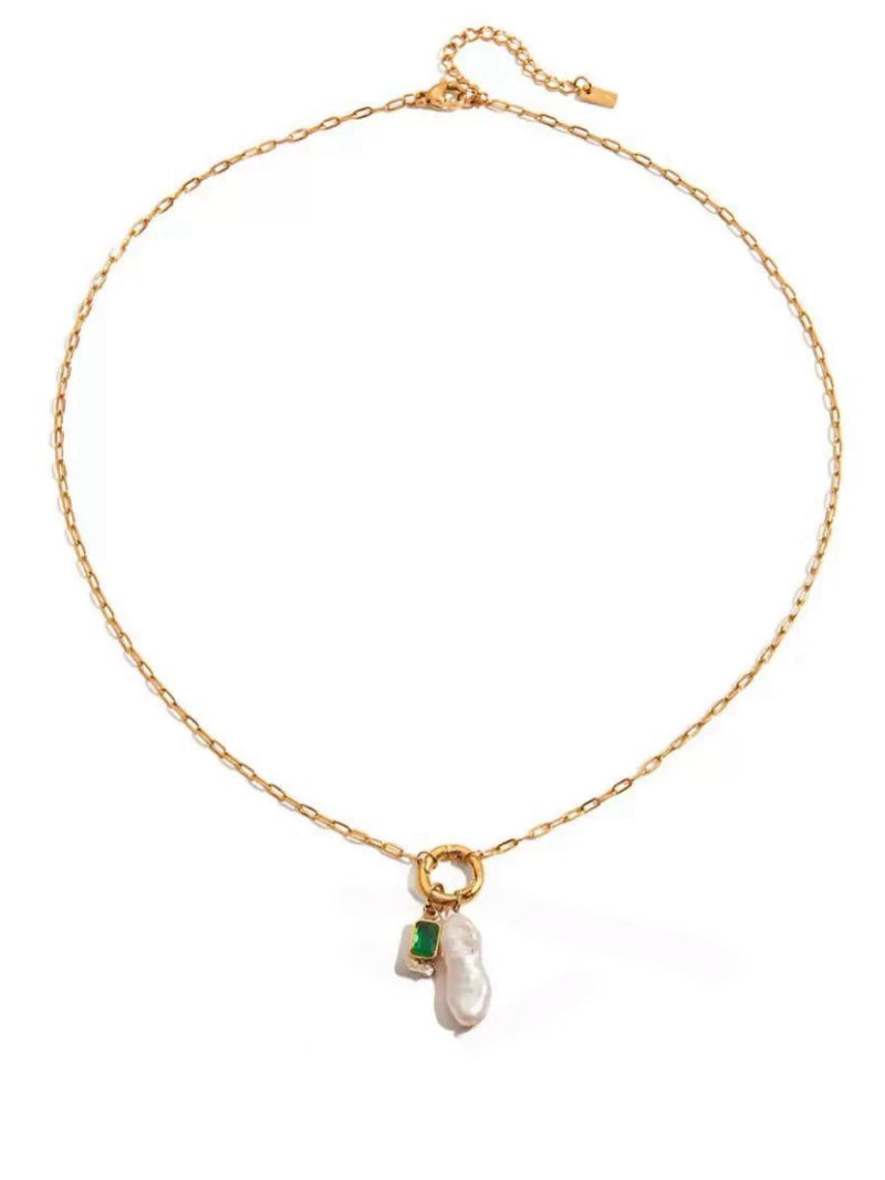 A gold-tone chain necklace with a pendant featuring an irregular baroque freshwater pearl and a small rectangular green gemstone set in a gold bezel.