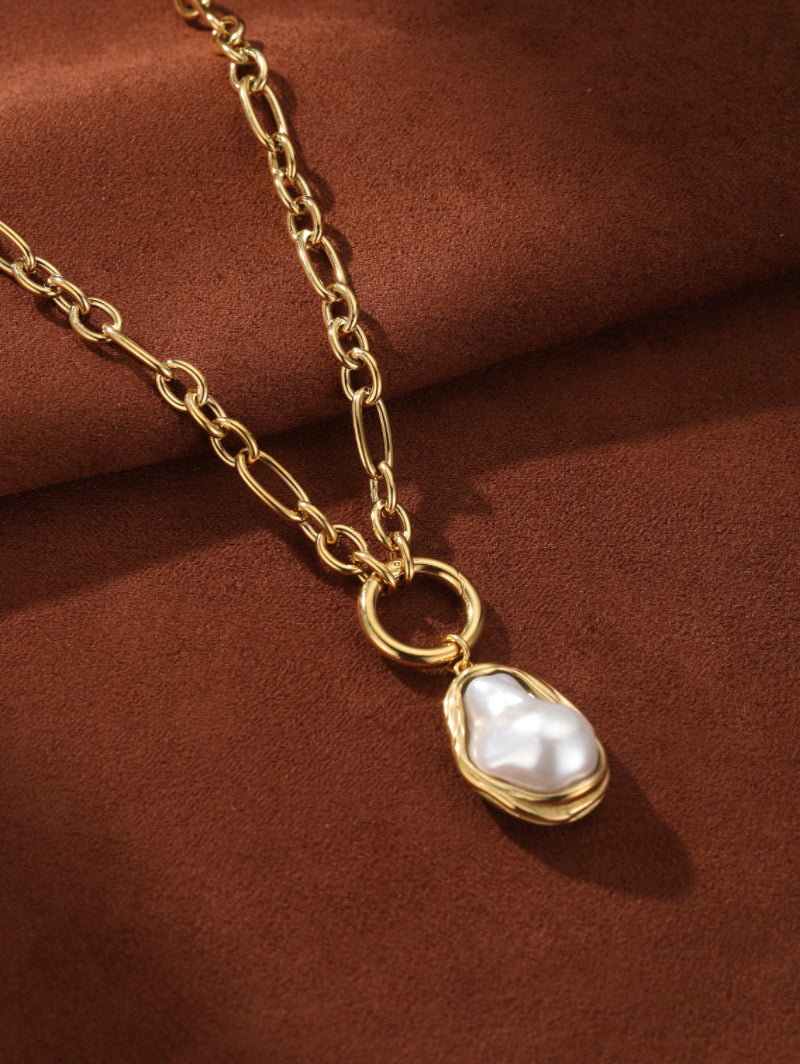 Golden Tide chunky chain necklace with a large, irregular white baroque freshwater pearl pendant in a textured gold-tone frame.